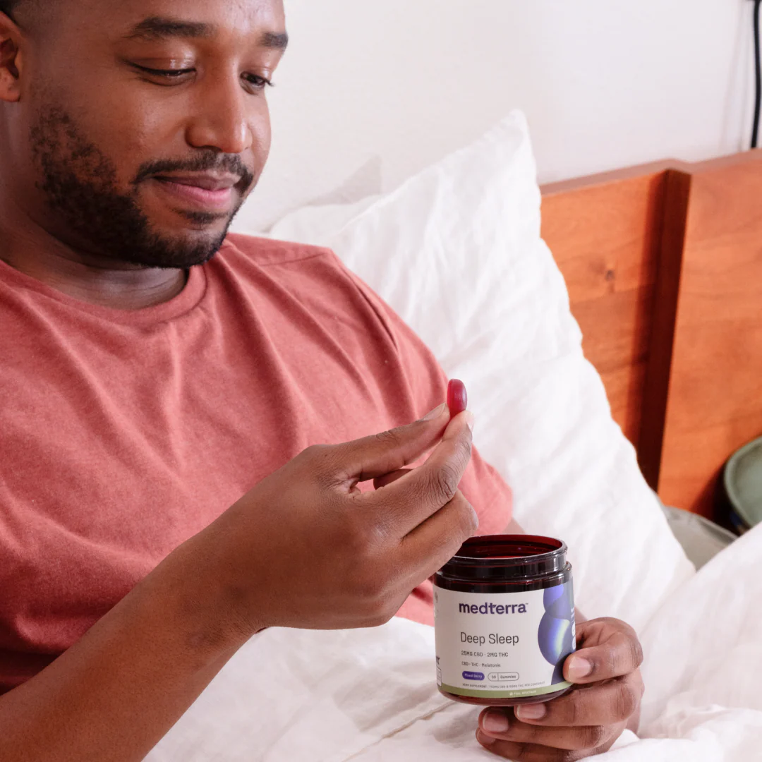 Front render of Medterra Deep Sleep showing 25 mg CBD and 2 mg THC label and three mixed berry gummies on white background