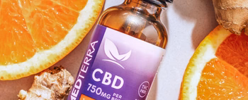 Bottle of Medterra CBD tincture labeled 'CBD 750MG PER BOTTLE THC FREE' surrounded by orange slices and ginger root.
