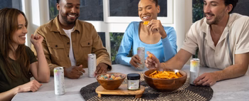A group of friends enjoying snacks and drinks while discussing CBD products.