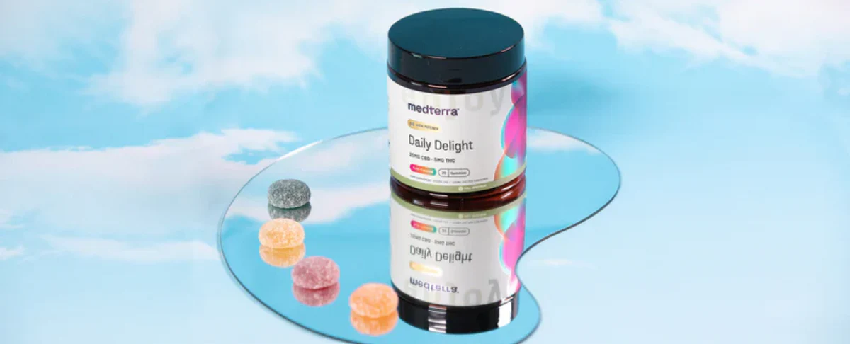 Daily Delight CBD Gummies jar with colorful gummies on a reflective surface