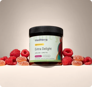 Front view of Medterra Extra Delight gummy jar labeled 25 mg CBD and 10 mg THC with raspberries on beige background