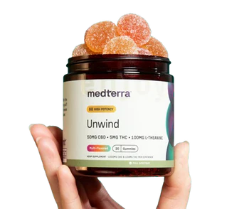 Medterra Unwind gummies jar held in hand, front label showing 50mg CBD and 5mg THC, sugar-coated gummies visible