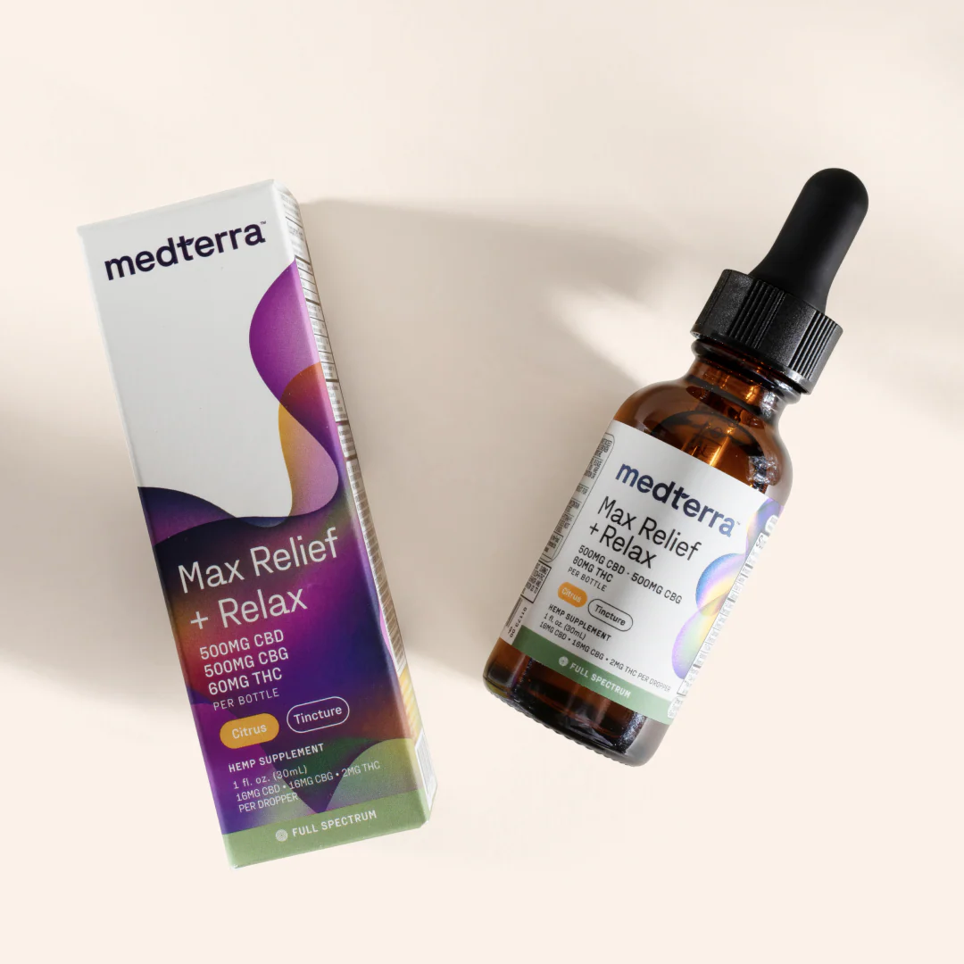 Angled view of Max Relief + Relax full spectrum tincture bottle and box showcasing label text and potency 500mg CBD, 500mg CBG, 60mg THC on pale beige background