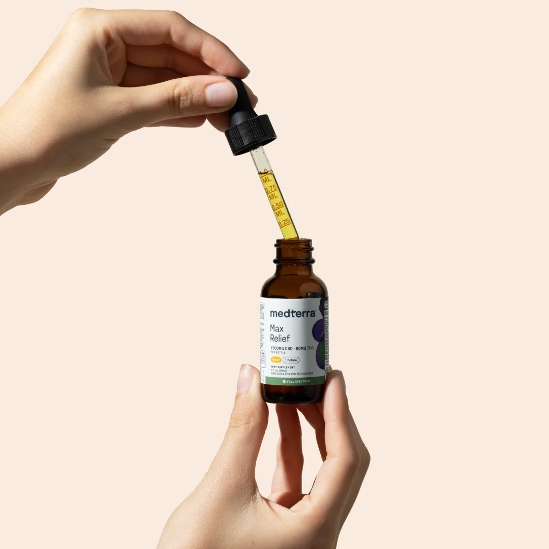 Handheld Max Relief Full Spectrum CBD Oil with graduated dropper markings and amber bottle on beige background