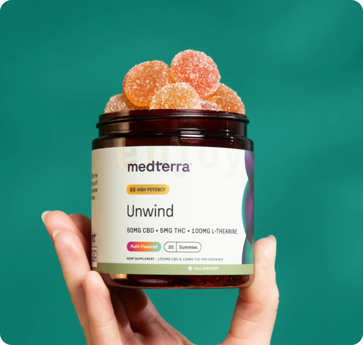 Front view of Unwind gummy jar showing sugar-coated gummies and label reading 50mg CBD, 5mg THC, 100mg L-theanine on teal background