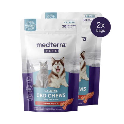 Two packs of Medterra's Pet CBD Calming Chews are displayed, each containing 30 bacon-flavored soft chews with 10mg of Pet CBD and L-Tryptophan per chew. The package showcases a cat and a dog, highlighting calming benefits and clinical testing.