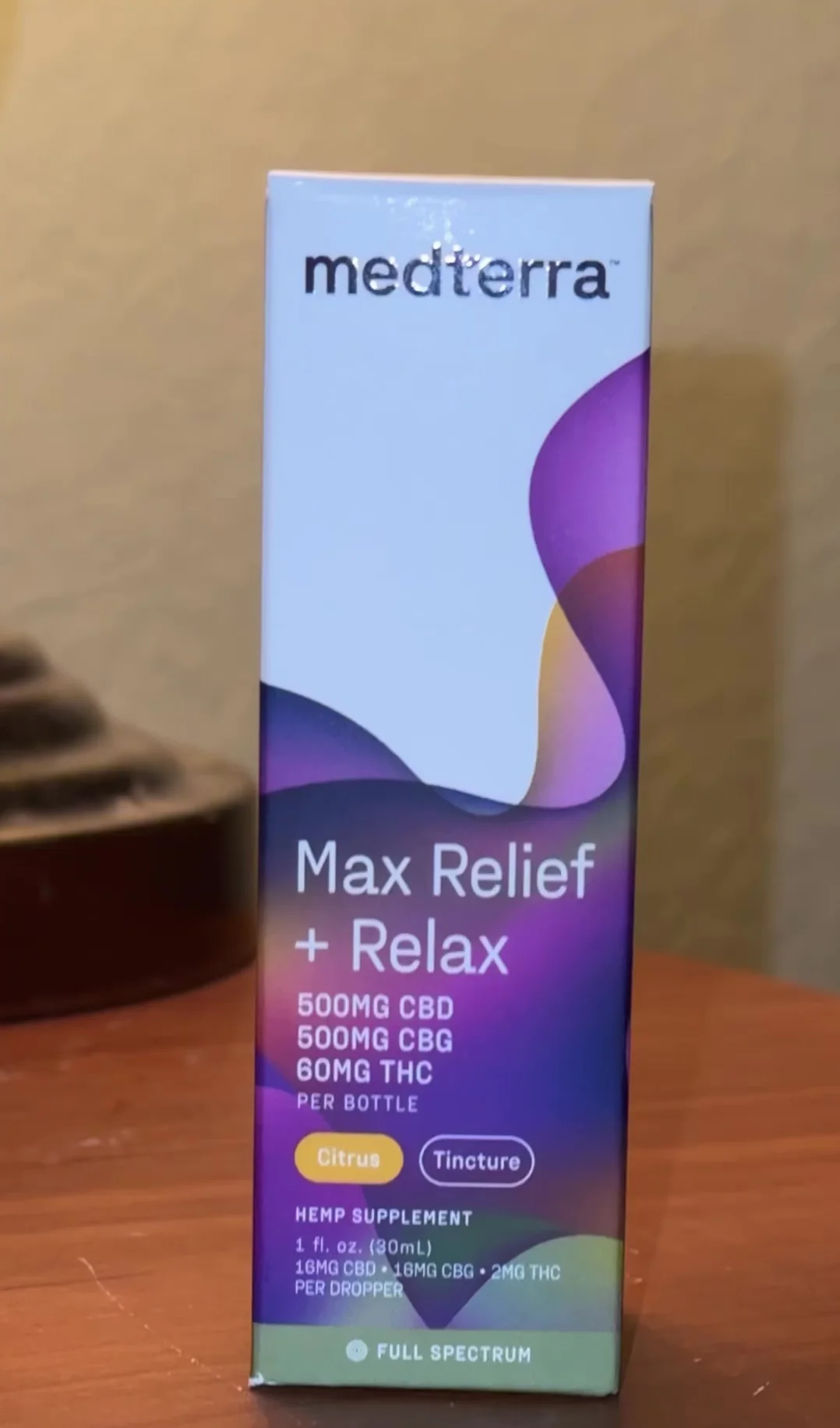 Front view of Medterra Max Relief and Relax full spectrum tincture box showing 500mg CBD, 500mg CBG, 60mg THC on a wood table