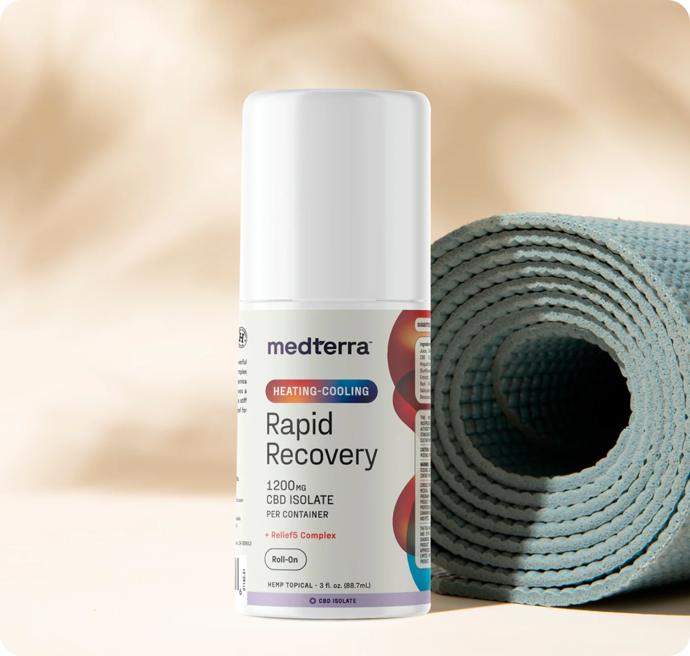 Front view of Heating-Cooling Rapid Recovery roll-on bottle showing Rapid Recovery label beside a blue rolled yoga mat