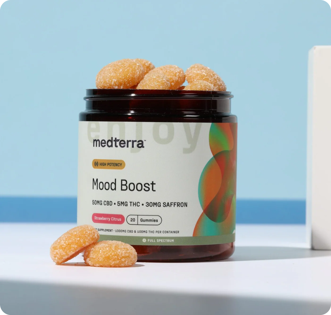 Front view of Mood Boost jar with strawberry citrus gummies and label showing Mood Boost and 50mg CBD on light blue background