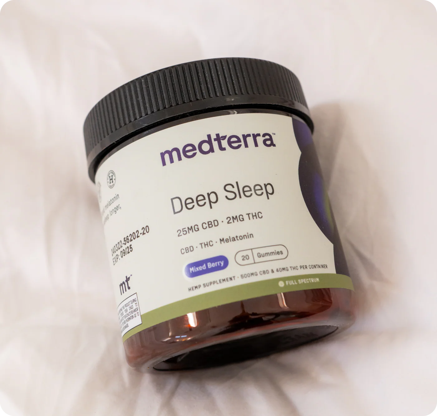 A Medterra Best Sellers Bundle jar of Deep Sleep CBD gummies—25mg CBD, 2mg THC, CBN, and melatonin in mixed berry flavor—rests on a white fabric surface.